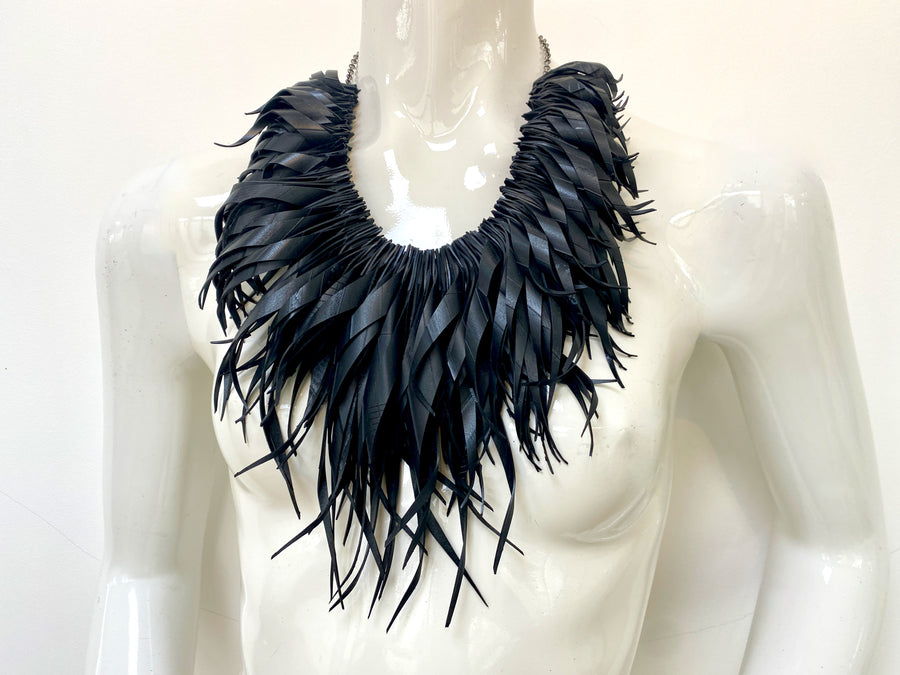 chunky, black large curly tassel necklace made from upcycled bicycle tyre inner tube on a white mannequin