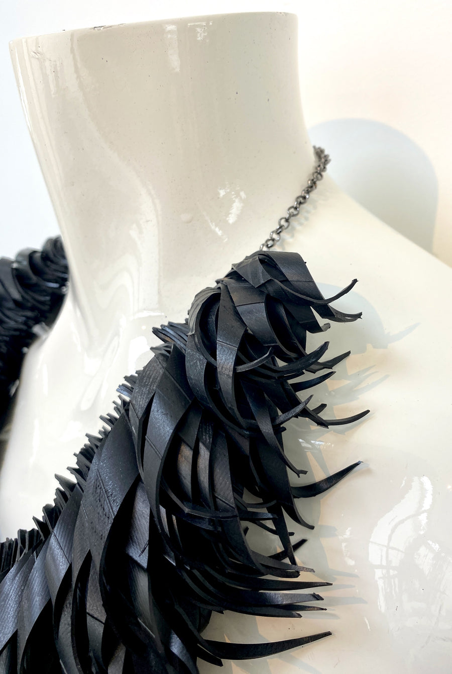 chunky, black large curly tassel necklace made from upcycled bicycle tyre inner tube on a white mannequin