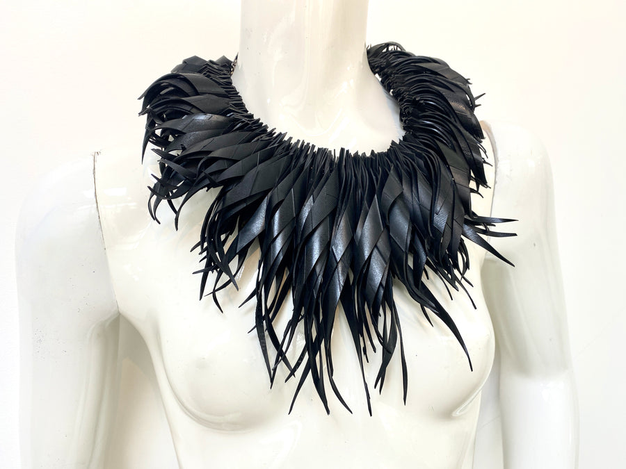 chunky, black large curly tassel necklace made from upcycled bicycle tyre inner tube on a white mannequin