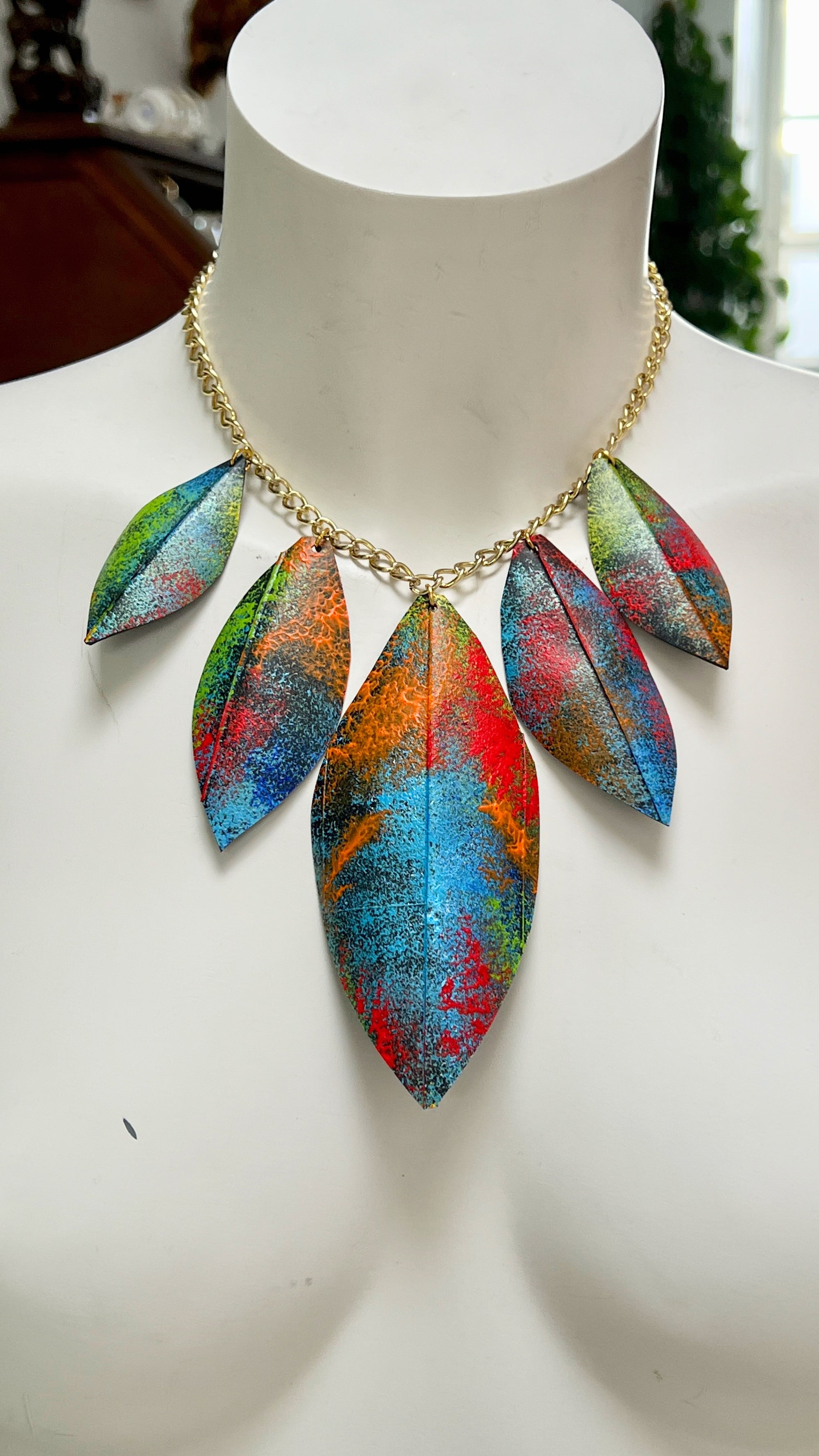Colorful leaf-shaped necklace made from upcycled bicycle inner tube rubber on a mannequin