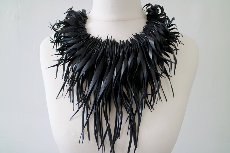 chunky, black large curly tassel necklace made from upcycled bicycle tyre inner tube on a white mannequin