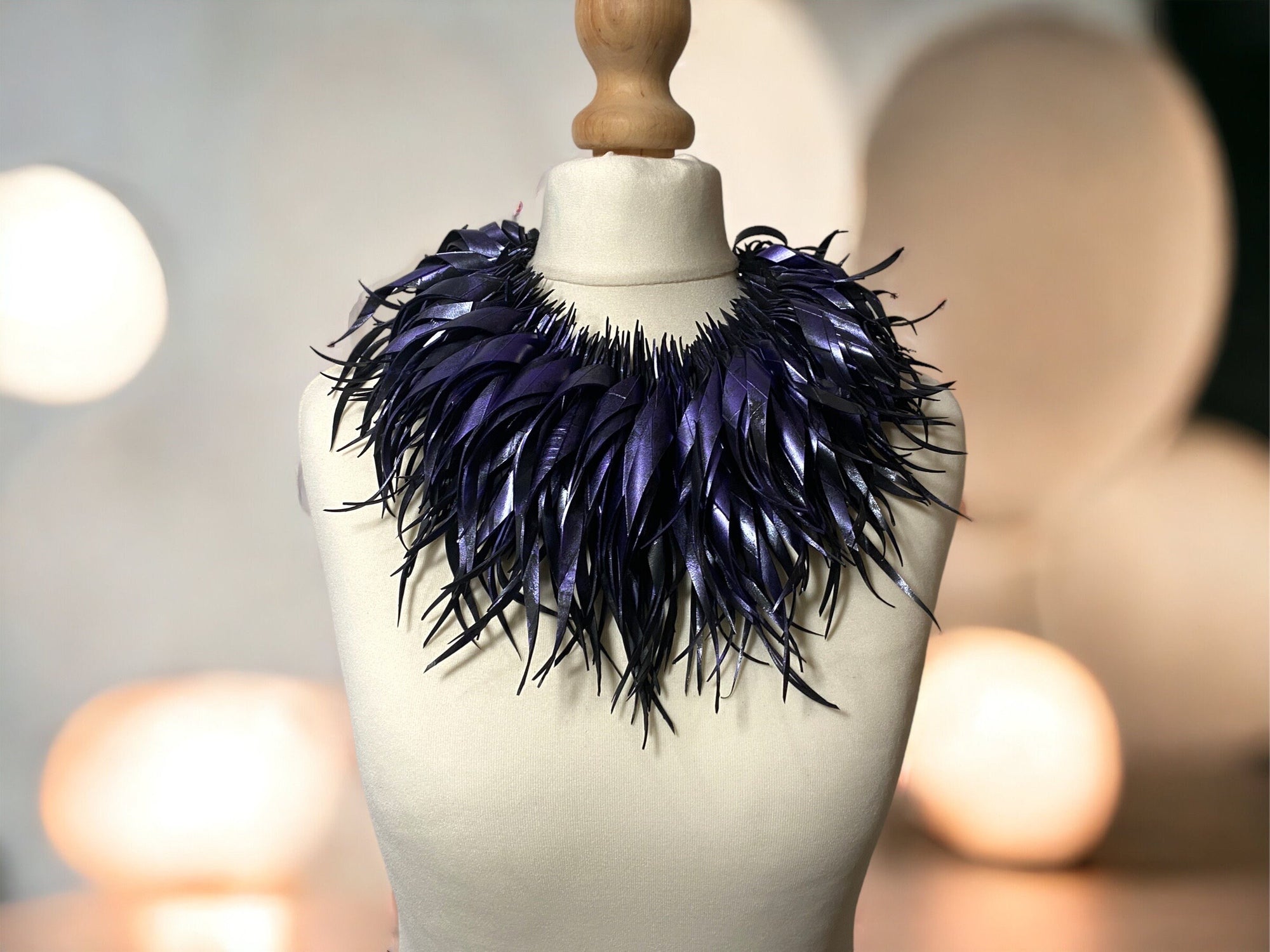 metallic purple, curly tassel necklace, chunky collar made from upcycled bicycle tyre rubber by laura zabo on a white mannequin against pastel background