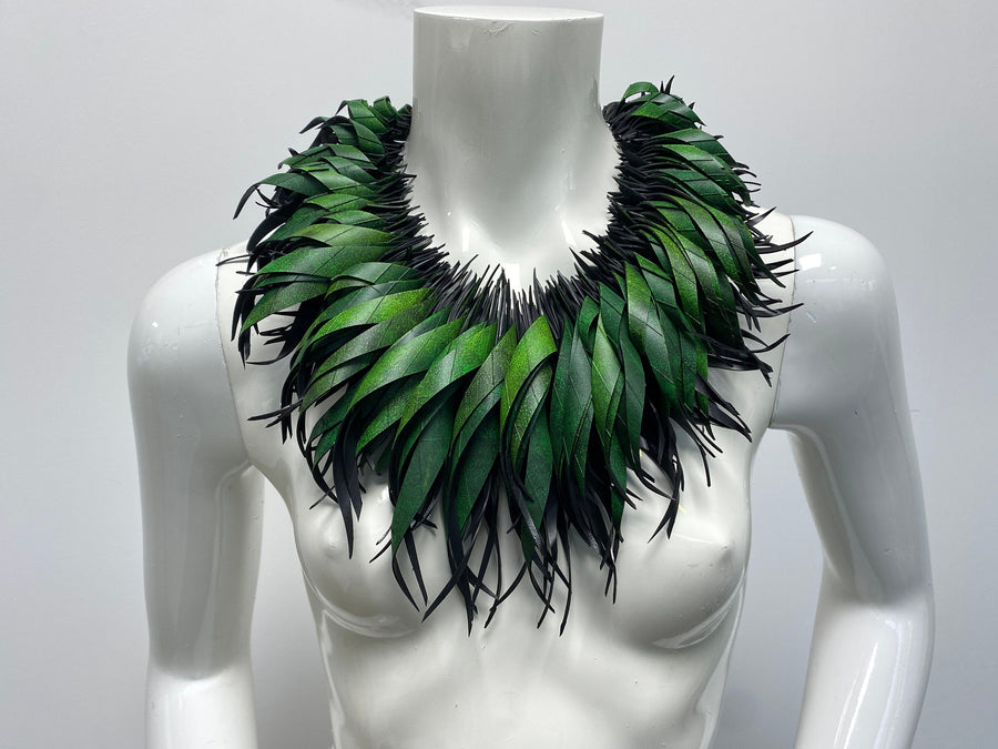 Green statement necklace, upcycled bicycle inner tube jewelry on a white mannequin