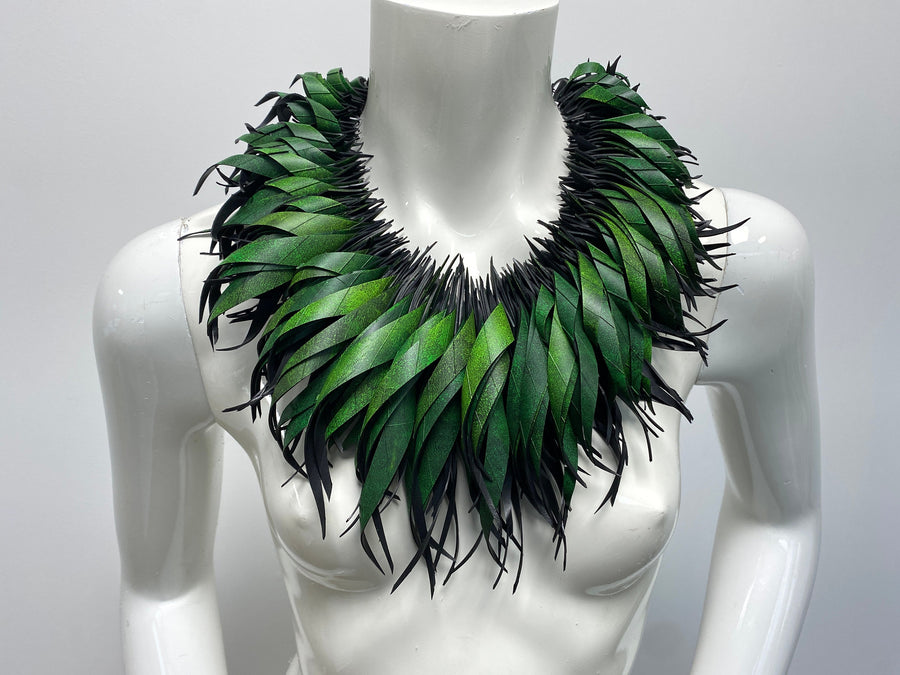 Green statement necklace, upcycled bicycle inner tube jewelry on a white mannequin