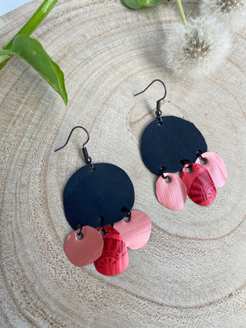 black red peach coloured upcycled nespresso capsules and bike inner tube rubber earrings on a wooden background