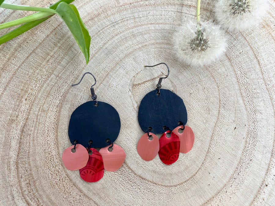 black red peach coloured upcycled nespresso capsules and bike inner tube rubber earrings on a wooden background