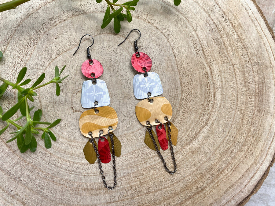 red silver and gold bohemian statement earrings made from upcycled Nespresso, coffee pods, on a wooden background and some leaves