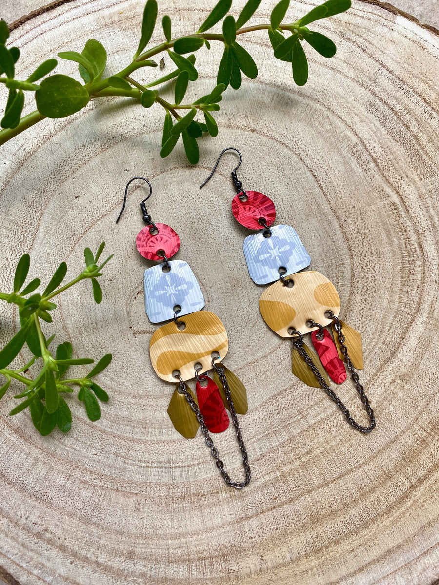 red silver and gold bohemian statement earrings made from upcycled Nespresso, coffee pods, on a wooden background and some leaves