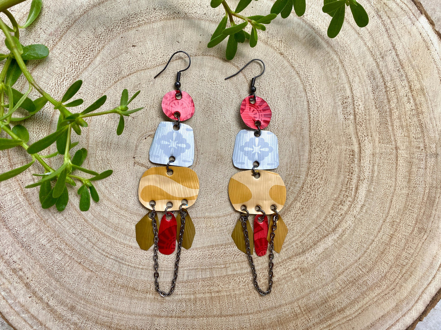 red silver and gold bohemian statement earrings made from upcycled Nespresso, coffee pods, on a wooden background and some leaves