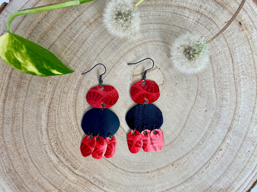 red black bohemian earrings, made from upcycled bicycle inner tubes and Nespresso capsules, on wooden background