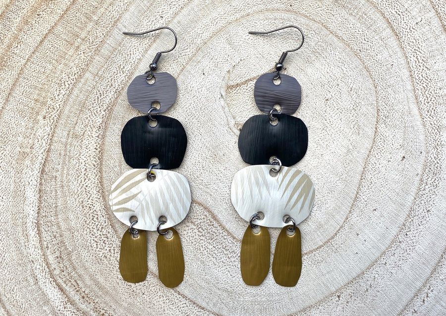 bold, upcycled Nespresso capsules, pod earrings, oriental designs on a wooden background