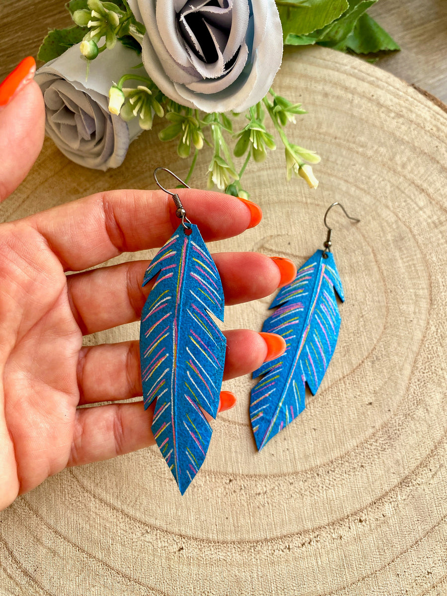 blue coloured leaf shaped, upcycled bicycle inner tube, rubber earrings on a wooden background