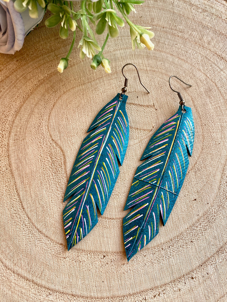 metallic aquamarine leaf shaped earrings made from upcycled bicycle tyre inner tubes on a wooden background