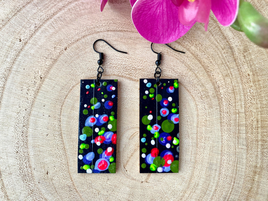 bubbly and eye catching squared earrings in black and neon colours made from upcycled bike inner tubes on a wooden background