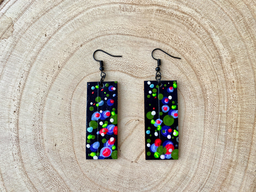 bubbly and eye catching squared earrings in black and neon colours made from upcycled bike inner tubes on a wooden background