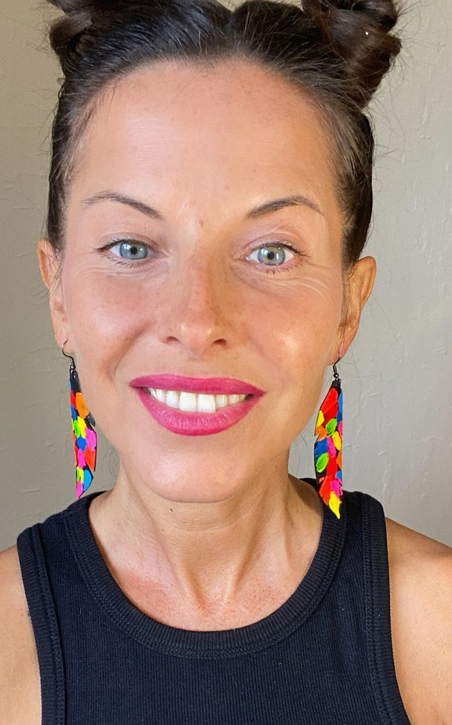 model wears pop art, abstract, neon coloured leaf shaped earrings made from upcycled bicycle inner tube rubber