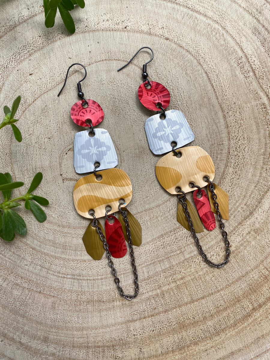 red silver and gold bohemian statement earrings made from upcycled Nespresso, coffee pods, on a wooden background and some leaves