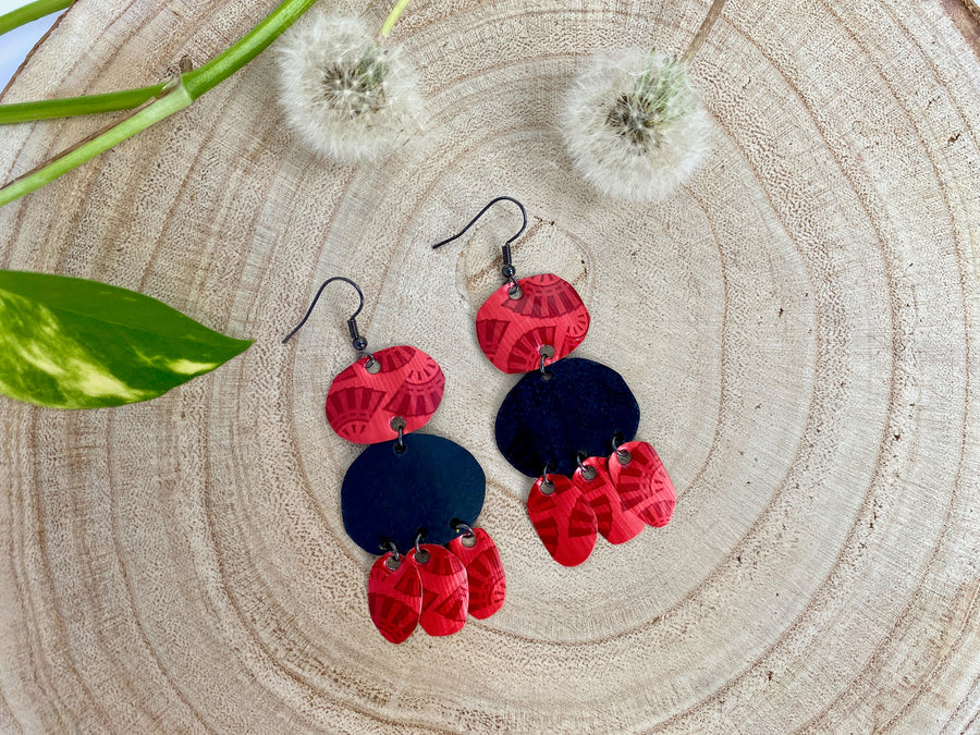 red black bohemian earrings, made from upcycled bicycle inner tubes and Nespresso capsules, on wooden background