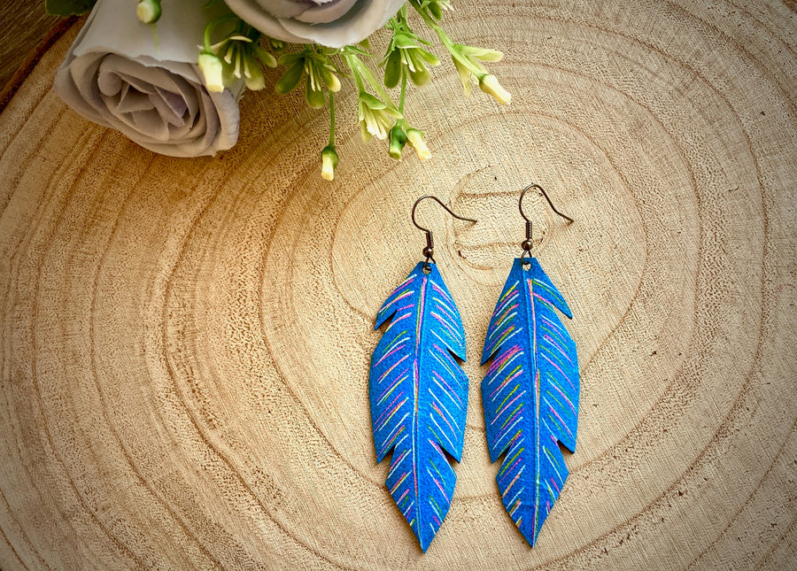 blue coloured leaf shaped, upcycled bicycle inner tube, rubber earrings on a wooden background