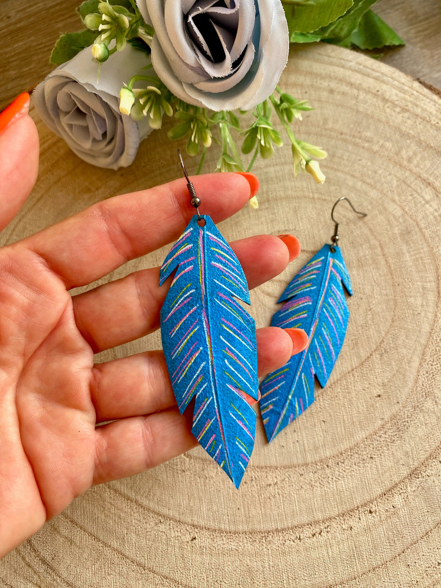 blue coloured leaf shaped, upcycled bicycle inner tube, rubber earrings on a wooden background