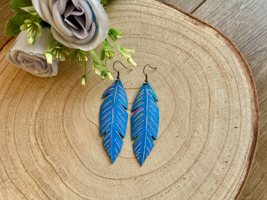 blue coloured leaf shaped, upcycled bicycle inner tube, rubber earrings on a wooden background