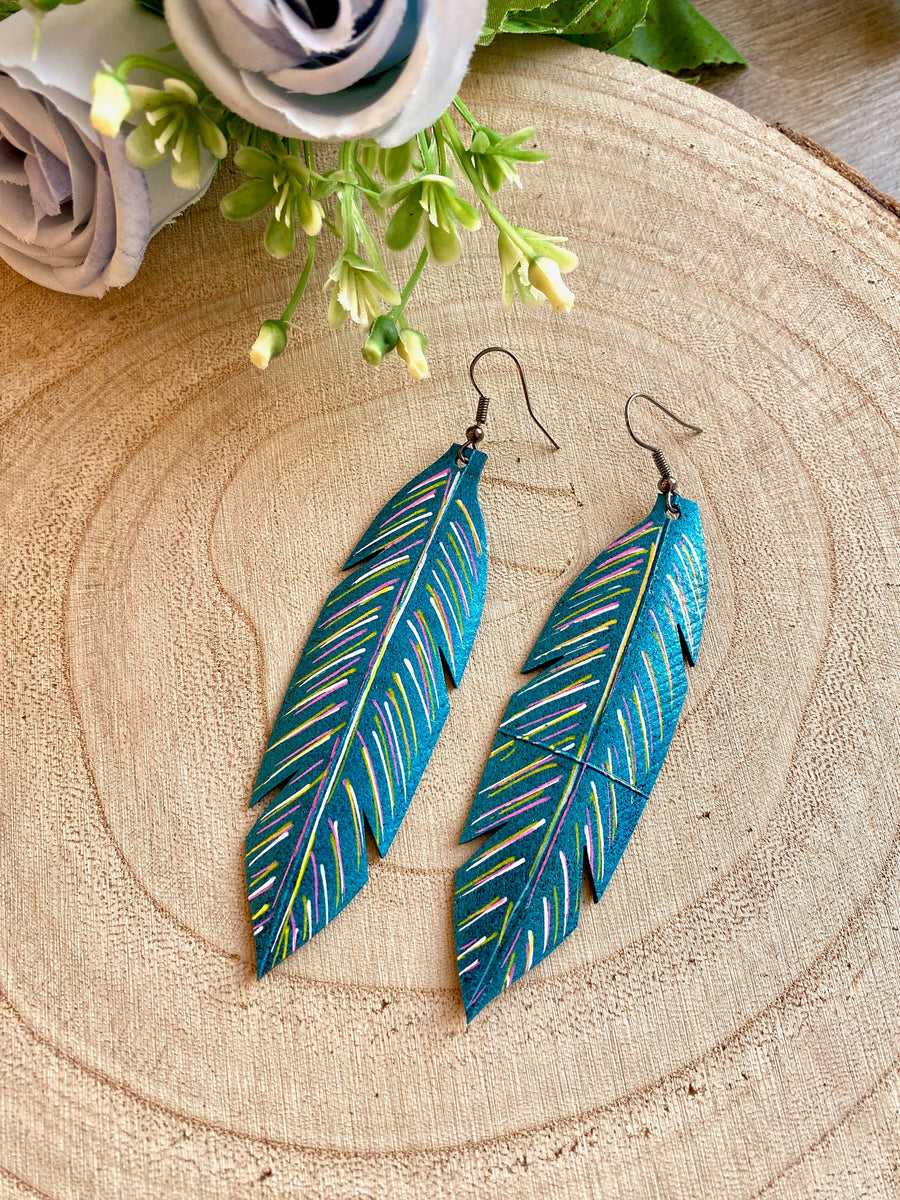 metallic aquamarine leaf shaped earrings made from upcycled bicycle tyre inner tubes on a wooden background