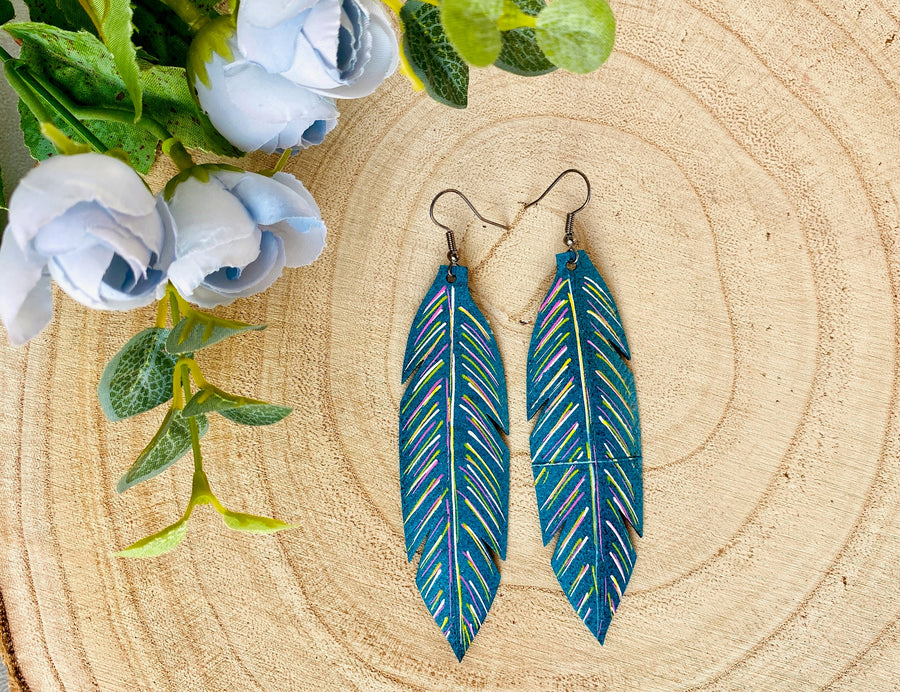 metallic aquamarine leaf shaped earrings made from upcycled bicycle tyre inner tubes on a wooden background