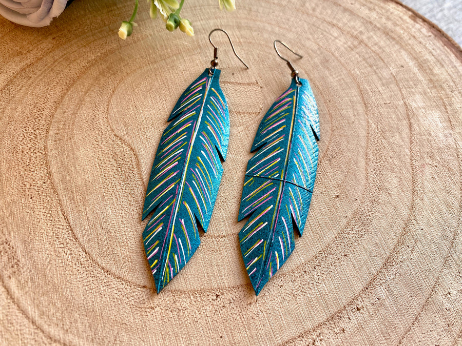 metallic aquamarine leaf shaped earrings made from upcycled bicycle tyre inner tubes on a wooden background