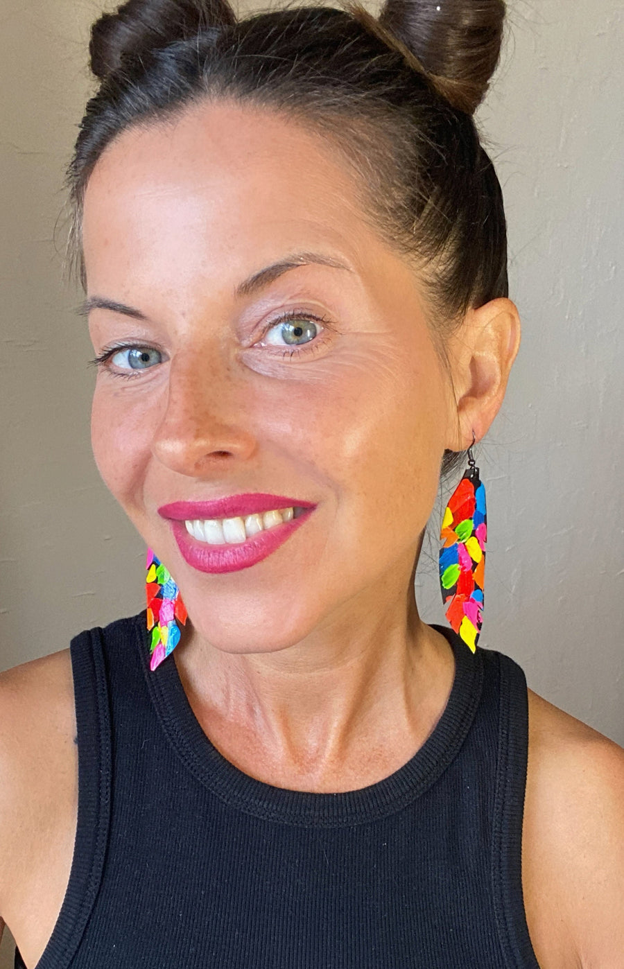 model wears pop art, abstract, neon coloured leaf shaped earrings made from upcycled bicycle inner tube rubber