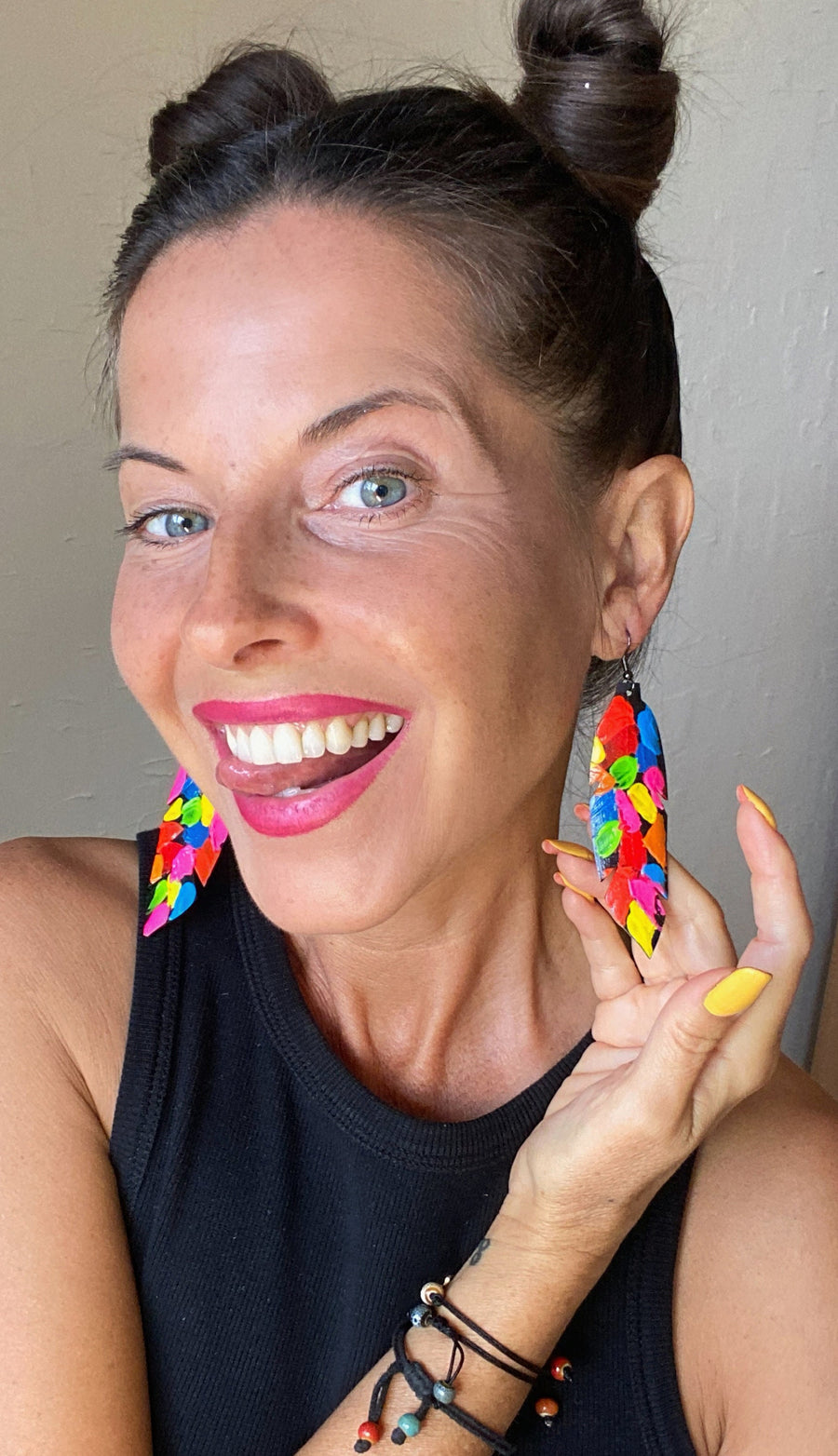 model wears pop art, abstract, neon coloured leaf shaped earrings made from upcycled bicycle inner tube rubber