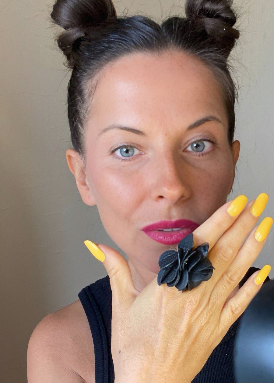 model wears black upcycled rubber, bicycle tube flower shaped statement ring