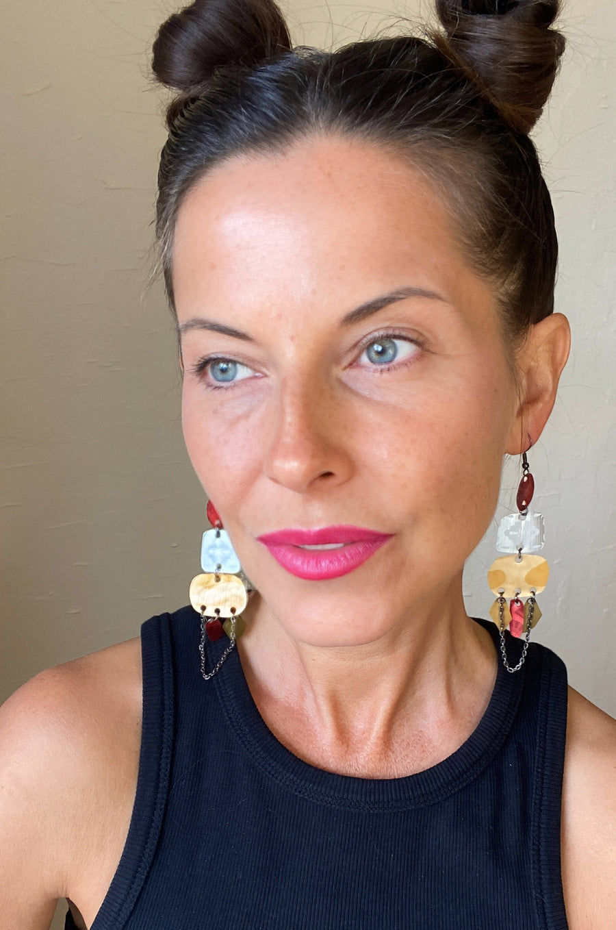 Laura Zabo wears red silver and gold bohemian statement earrings made from upcycled Nespresso, coffee pods