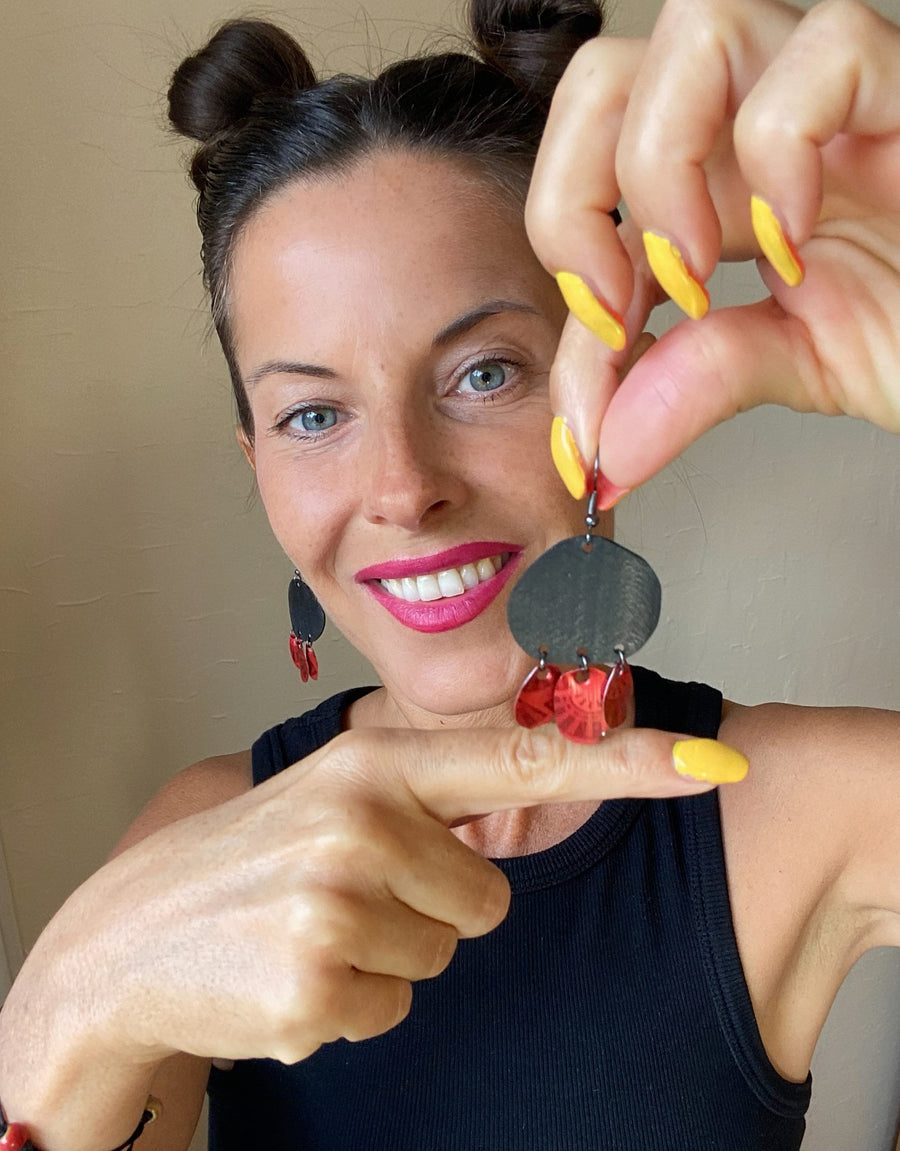 model holds Bohemian, red black upcycled bike inner tube and Nespresso pod earrings