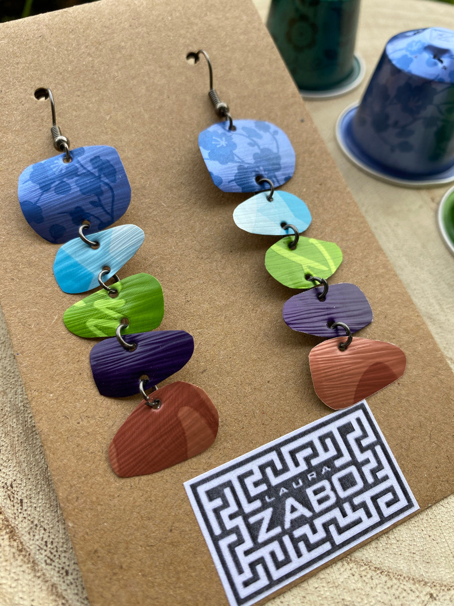 zen, yoga inspired colourful earrings made from upcycled nespresso capsules on a wooden background with few nespresso pods and Laura Zabo logo