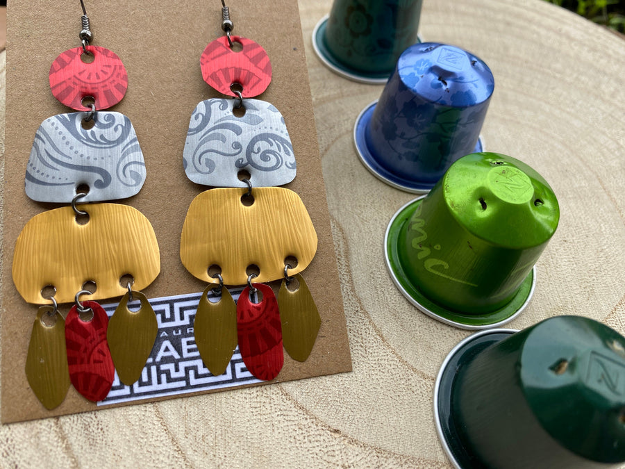 large, long, red, silver, golden earrings made from upcycled nespresso capsules on a wooden background decorated with few nespresso pods