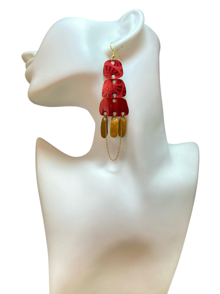 Golden red large earrings made from upcycled nespresso capsules on a white earrings display and white background