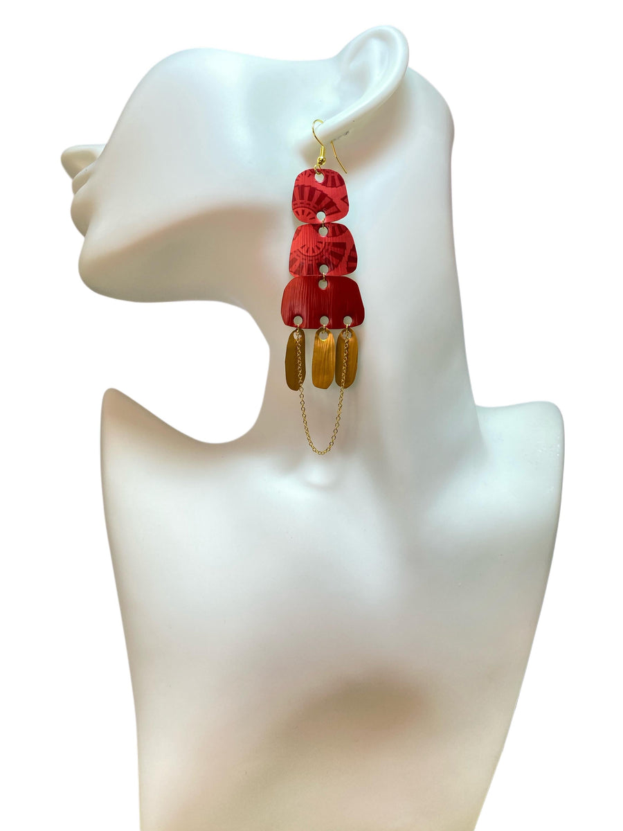 Golden red large earrings made from upcycled nespresso capsules on a white earrings display and white background