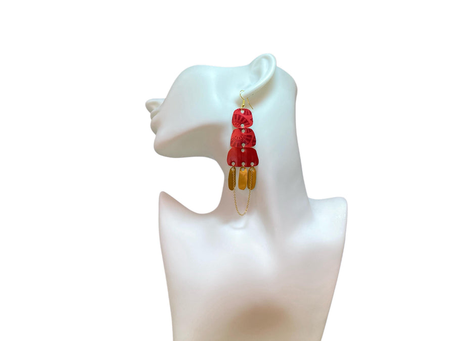 Golden red large earrings made from upcycled nespresso capsules on a white earrings display and white background