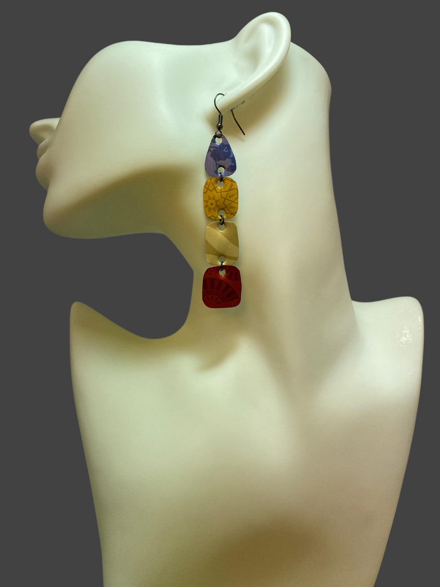 blue, brown, red, colourful earrings made from upcycled nespresso pods on awhite mannequin and grey background