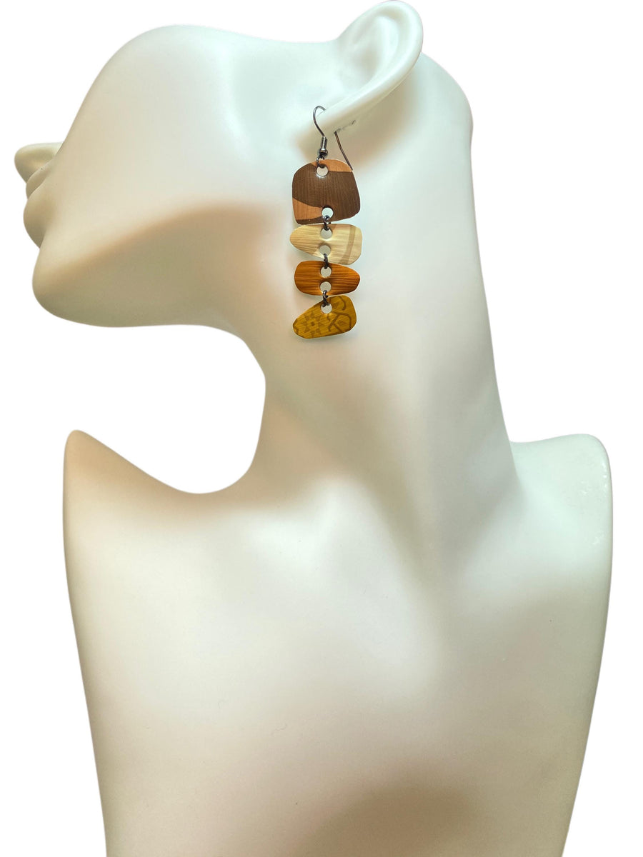 Earthy coloured, brown, sand mustard, gold earrings made from upcycled nespresso capsules on a white mannequin and white background