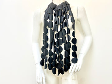 large bold necklace featuring 9 long tassels, each crafted from 10 upcycled rubber circles connected by jump rings on a white mannequin