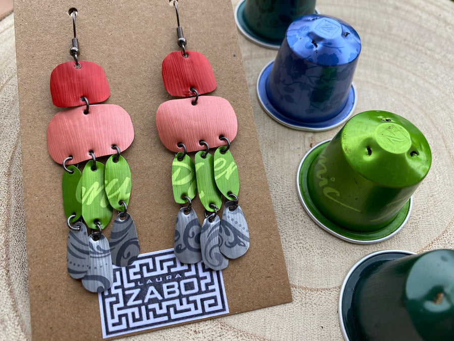 colourful oriental design earrings in red, peach, green and grey colour made from upcycled nespresso capsules on a wooden background and with few whole nespresso pods