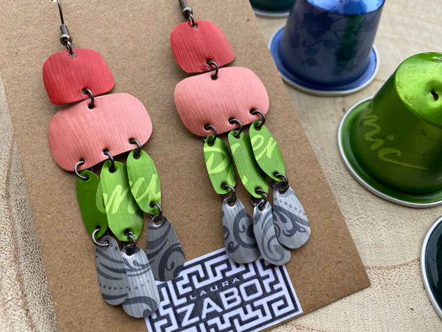 colourful oriental design earrings in red, peach, green and grey colour made from upcycled nespresso capsules on a wooden background and with few whole nespresso pods