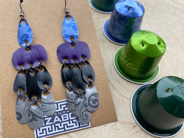 blue purple black silver earrings, oriental design made from upcycled nespresso capsules on a wooden background with a few whole nespresso pods