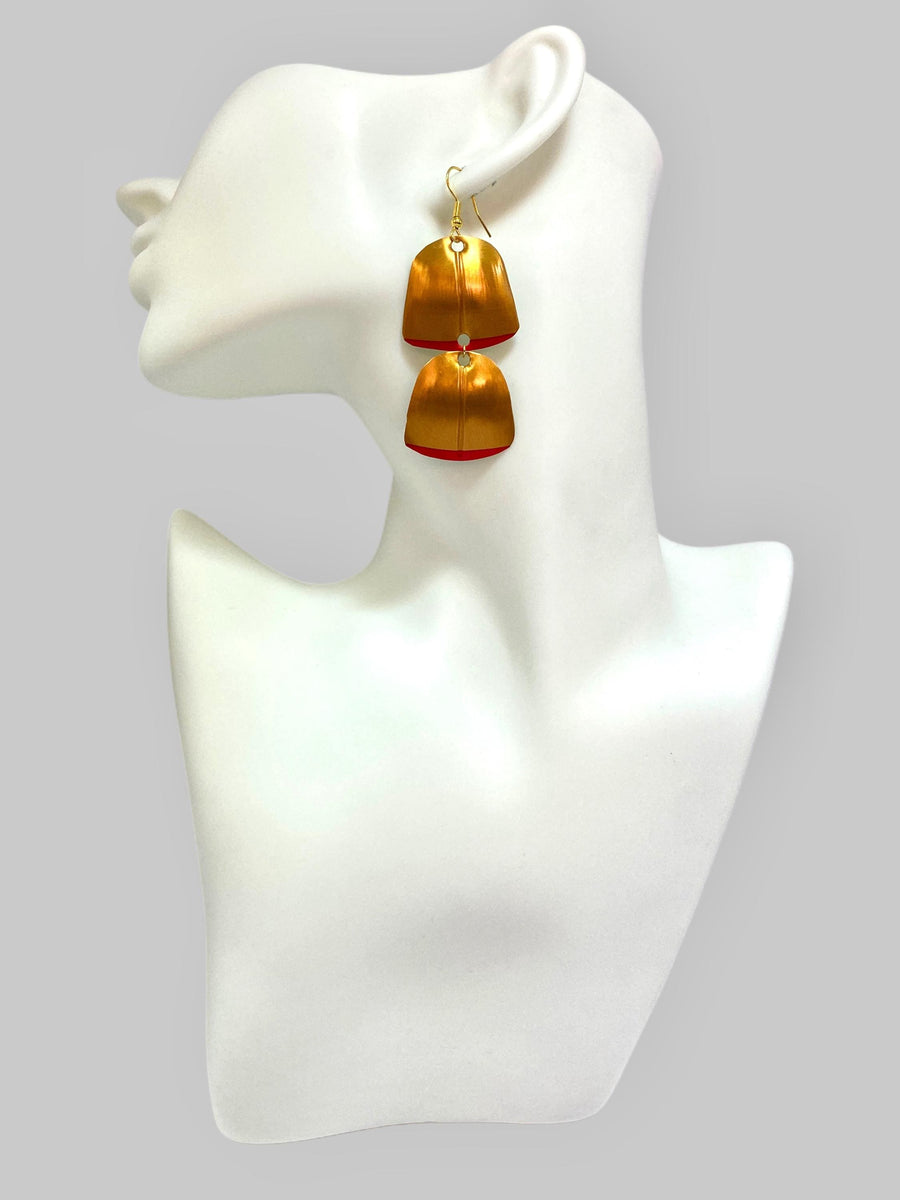 Gold red geometric and asymmetric earring made from upcycled upcycled nespresso capsules on a mannequin and grey background