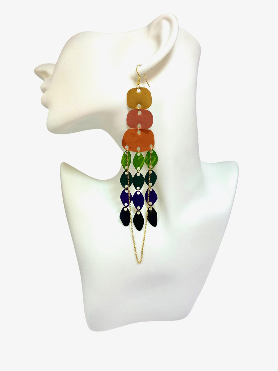 large, rainbow coloured chandelier earrings made from colourful Nespresso pods with a golden chain, on a white mannequin and white background