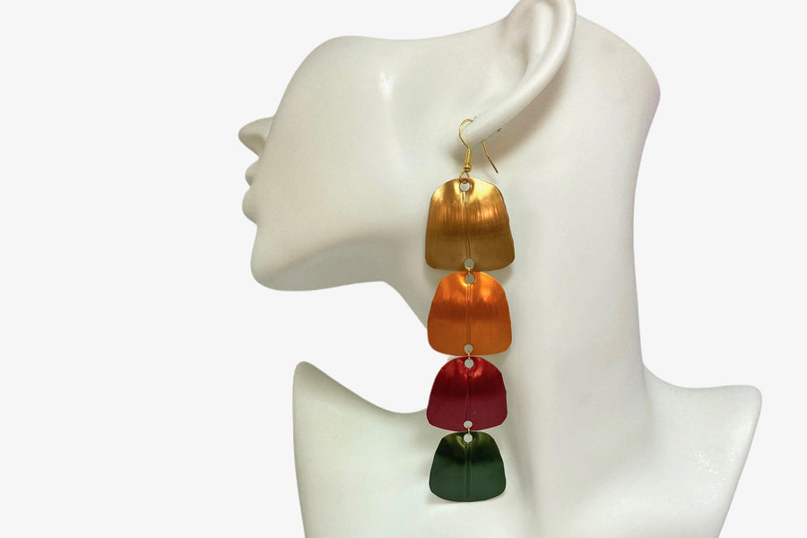 gold orange red green statement earrings made from Upcycled nespresso capsules on a white mannequin and white background