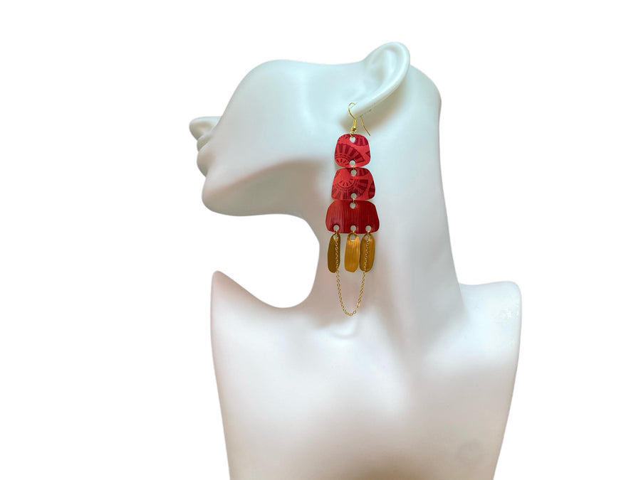 Golden red large earrings made from upcycled nespresso capsules on a white earrings display and white background