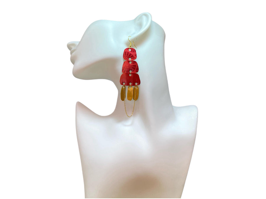 Golden red large earrings made from upcycled nespresso capsules on a white earrings display and white background