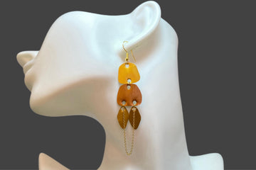 gold, copper, bronze upcycled nespresso capsules earrings on a white mannequin and grey background